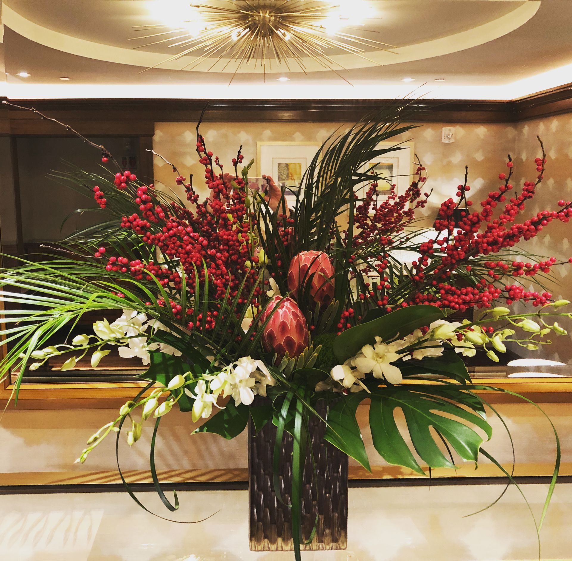 A vase filled with red and white flowers sits on a table