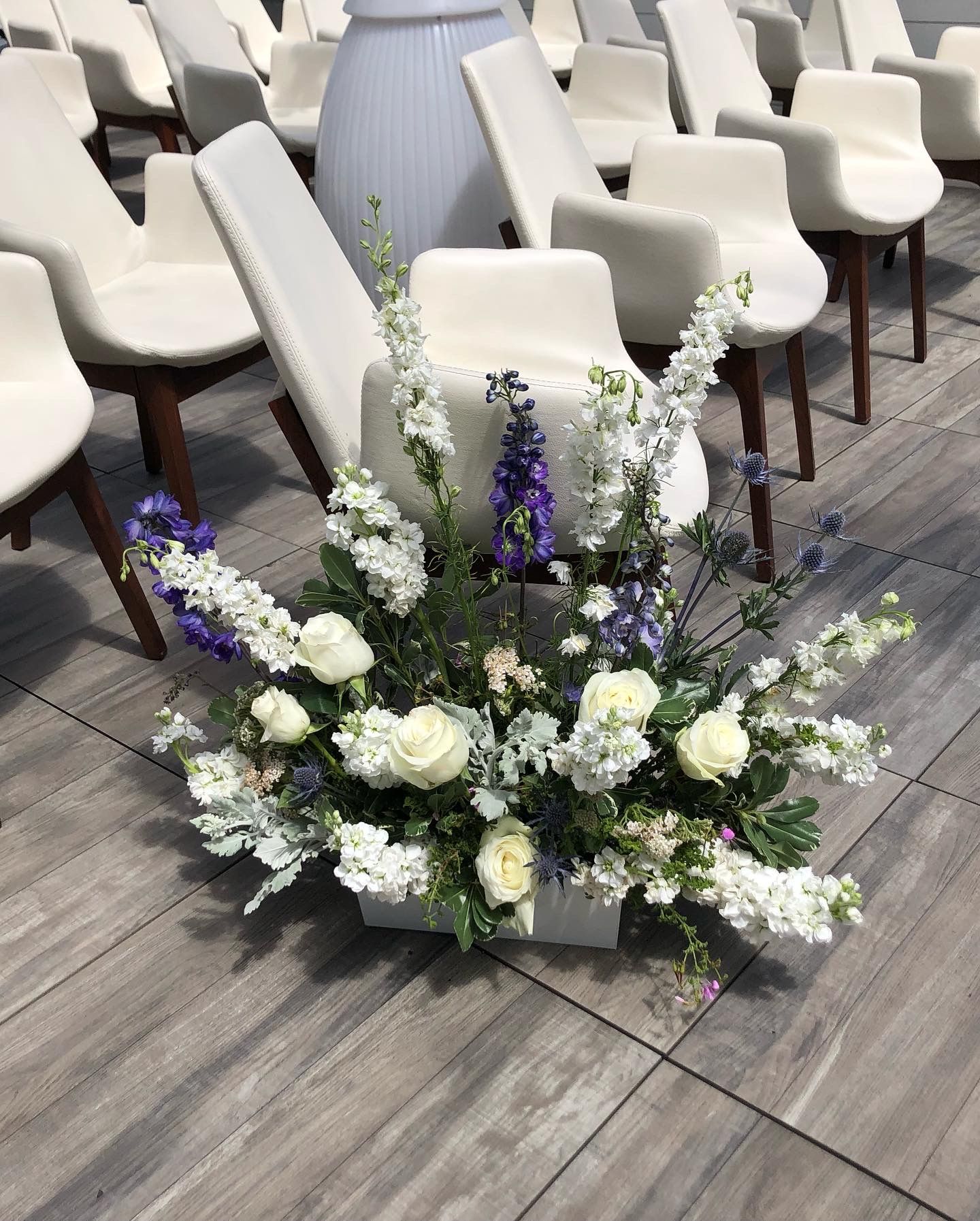Aisle flowers in white and blue for a wedding.