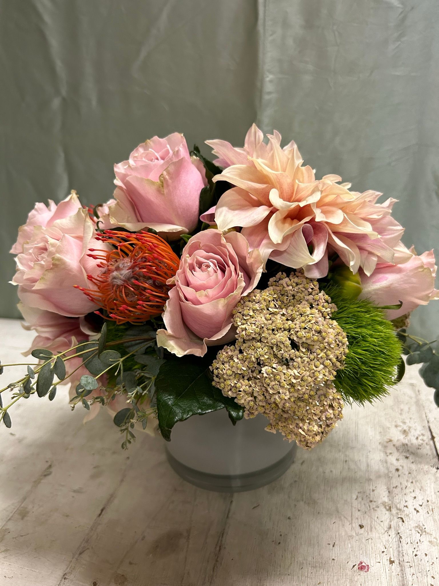A vase filled with pink flowers is sitting on a table.
