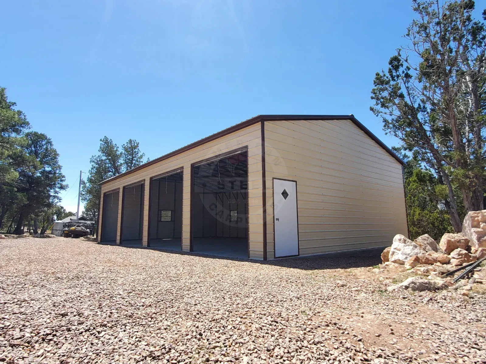 a large building with a white door is sitting in the middle of a gravel lot