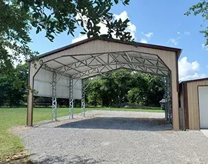 a large metal building with a driveway underneath it