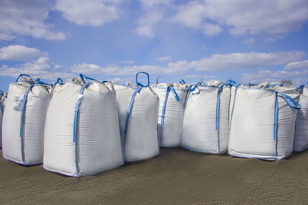 A Bunch Of White Bags With Blue Straps Are Stacked On Top Of Each Other — Arnway Pty Ltd In Kempsey, NSW