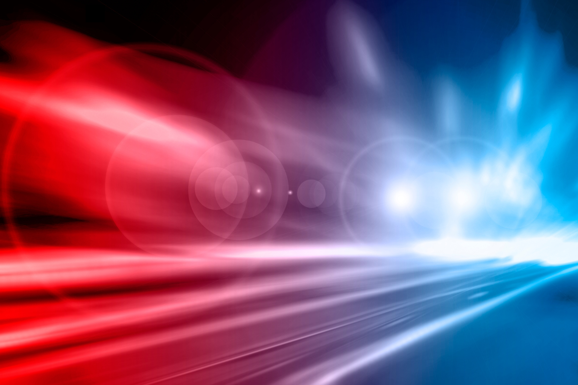 A red , white and blue light is shining on a dark background.