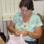 Woman working on pink fabric — Authorized Dealer in Pensacola FL