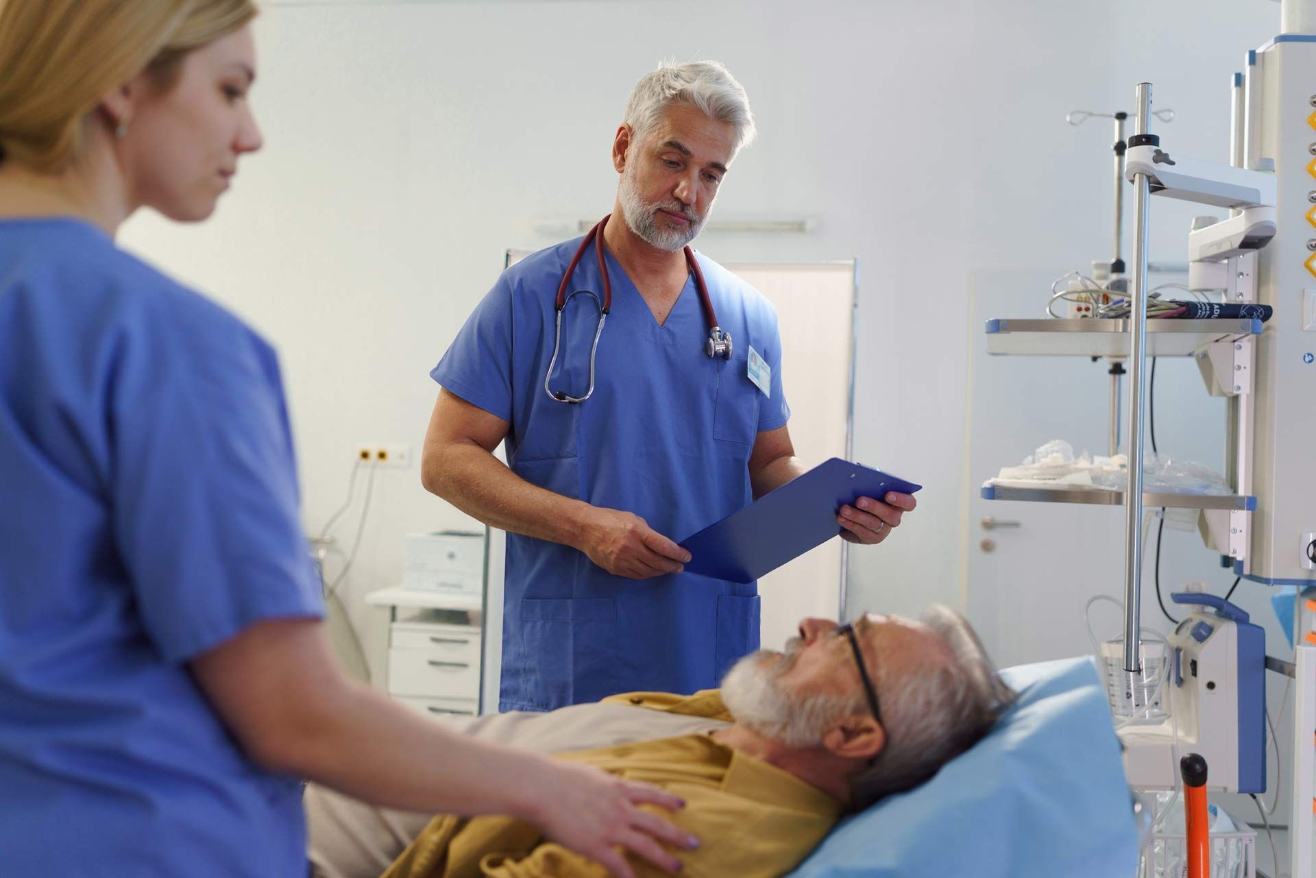 A doctor and nurse are examining a patient in an emergency room at an urgent care medical center. A doctor and nurse are examining a patient in an emergency room at an urgent care medical center.