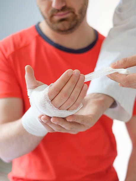 A man is getting his wrist bandaged by a doctor.