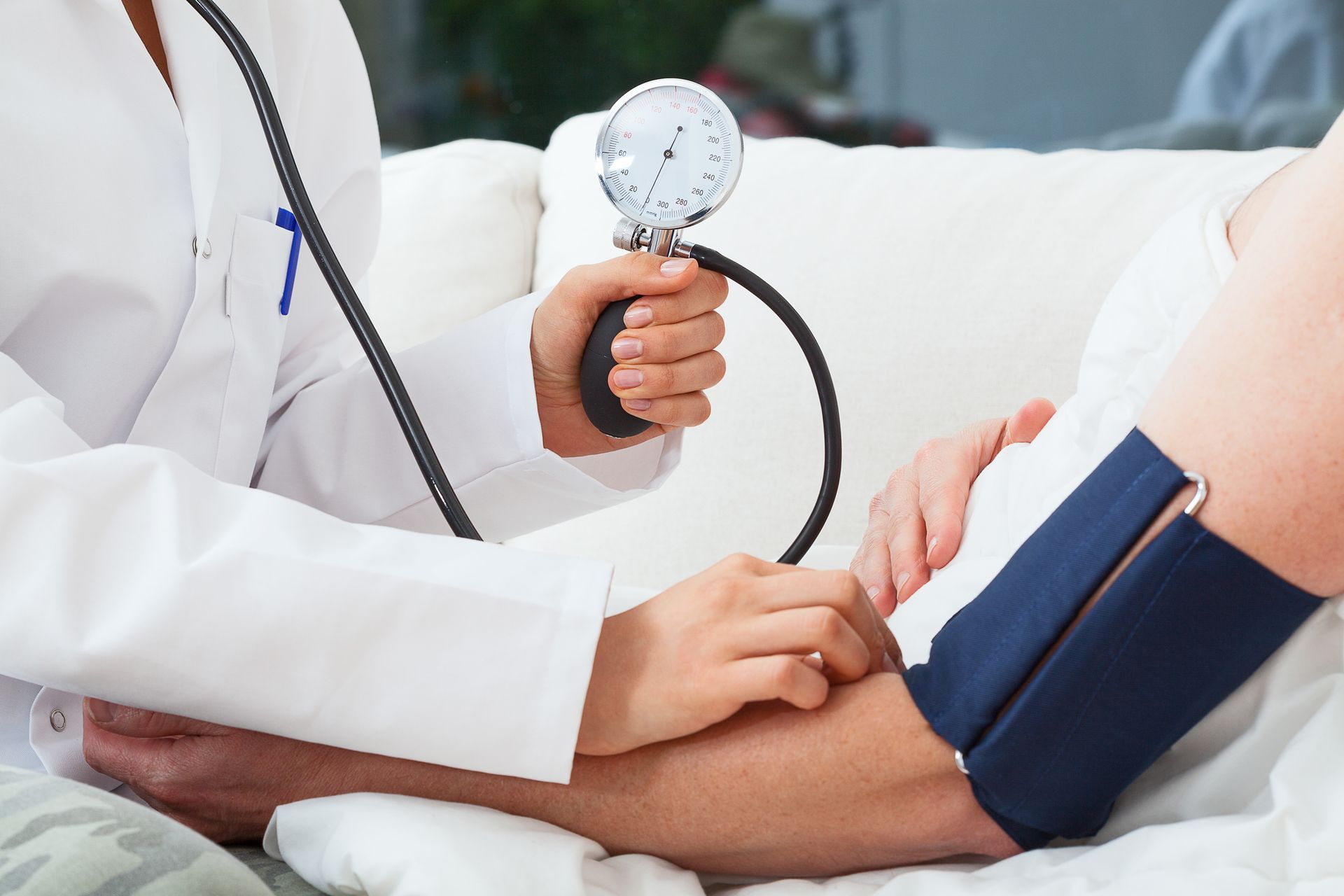 Doctor checking patient's blood pressure with manual cuff during medical exam.