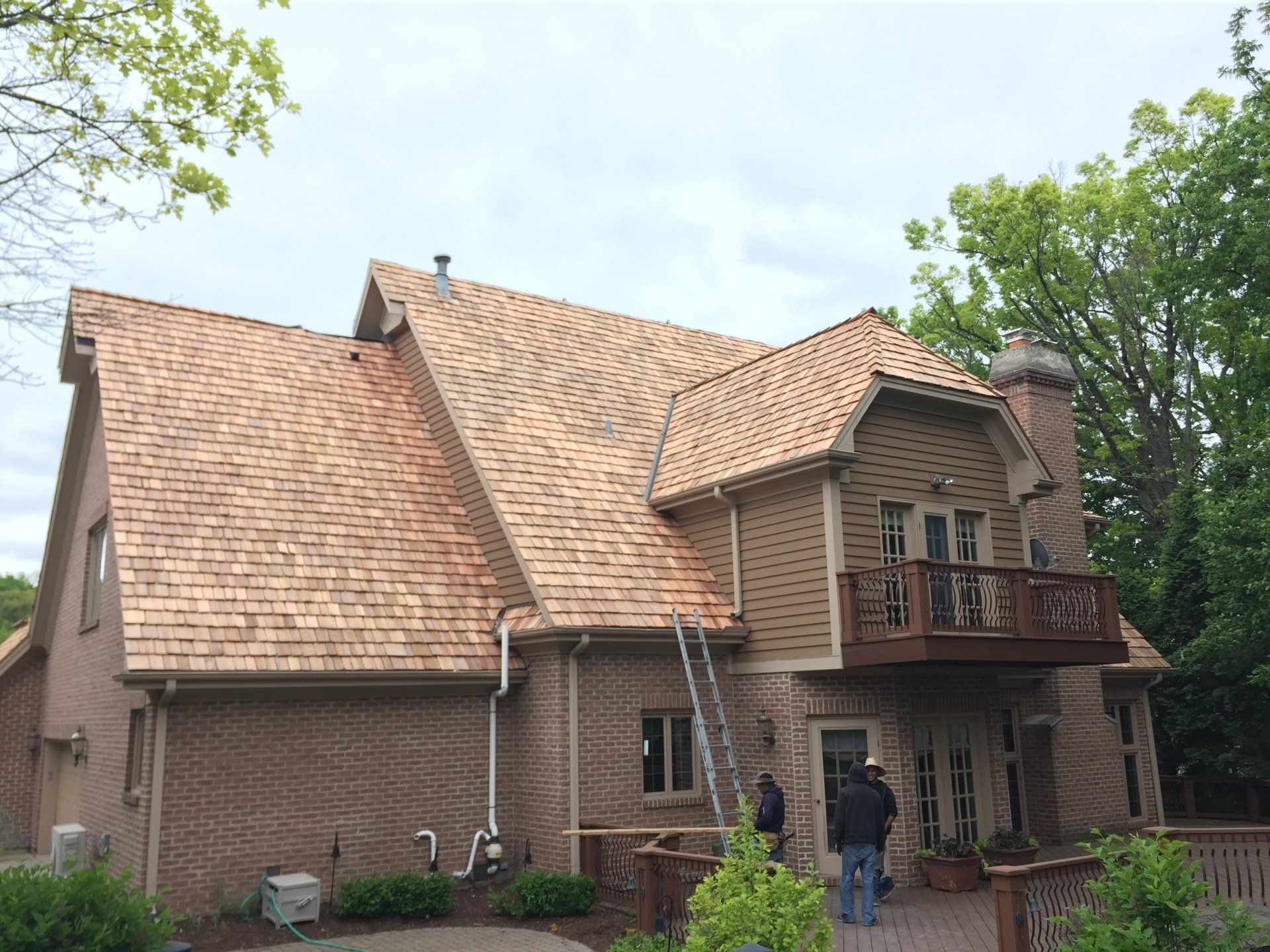 A large brick house with a wooden roof and a deck.