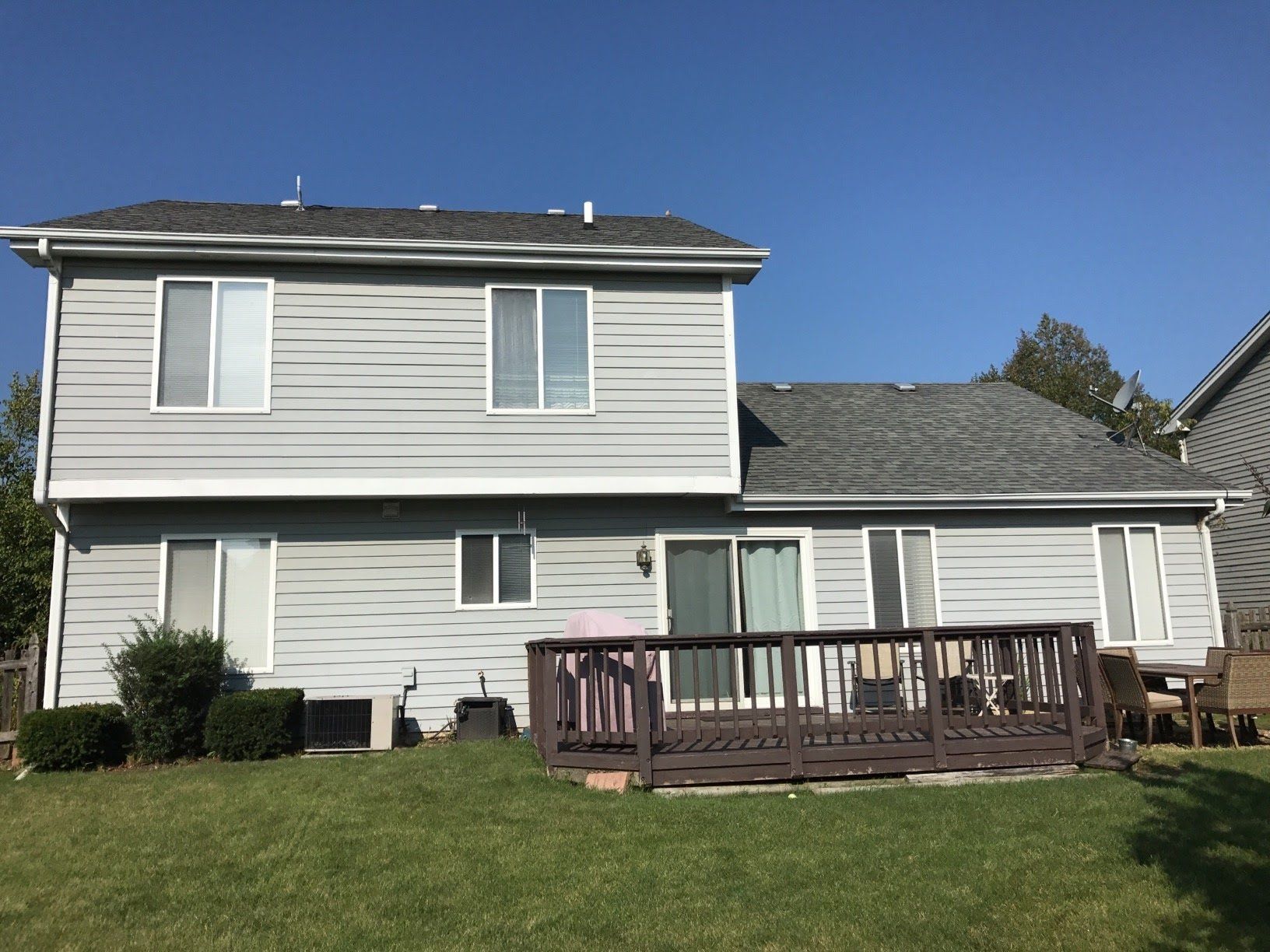 The back of a house with a deck and a sliding glass door.