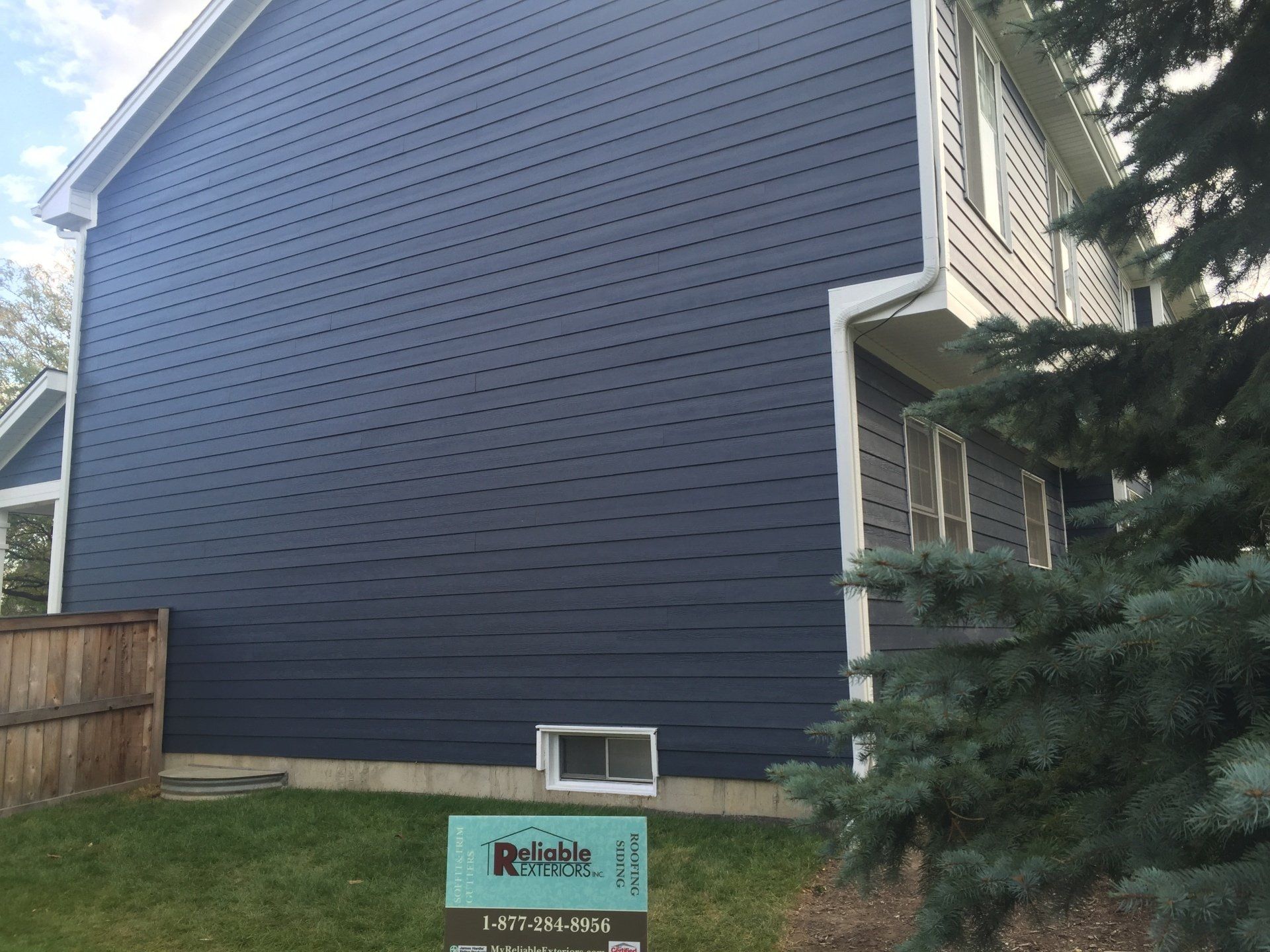 A house with a blue siding has a sign in front of it that says retaka