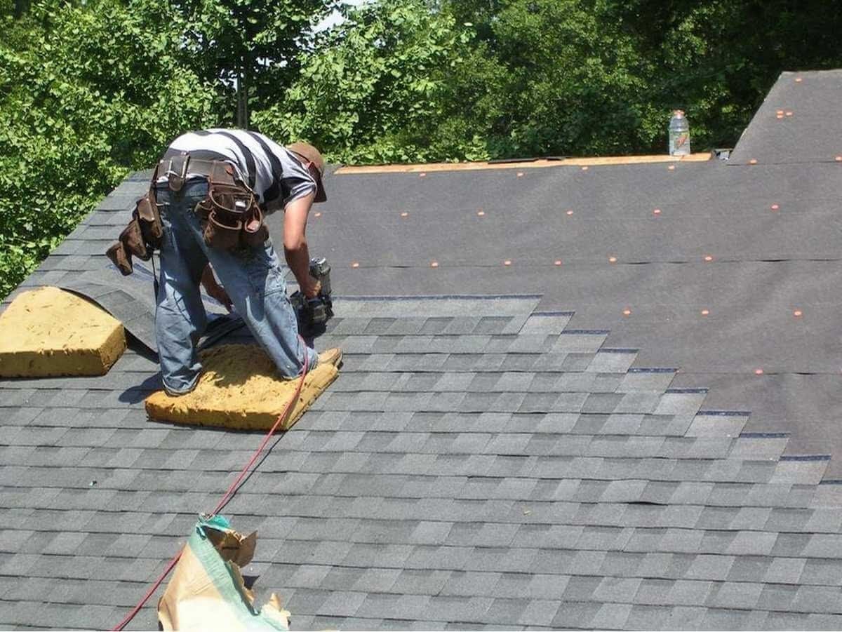 A man is working on the roof of a house