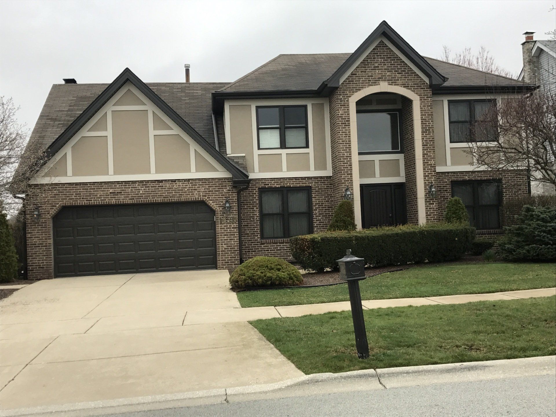 A large brick house with a black garage door