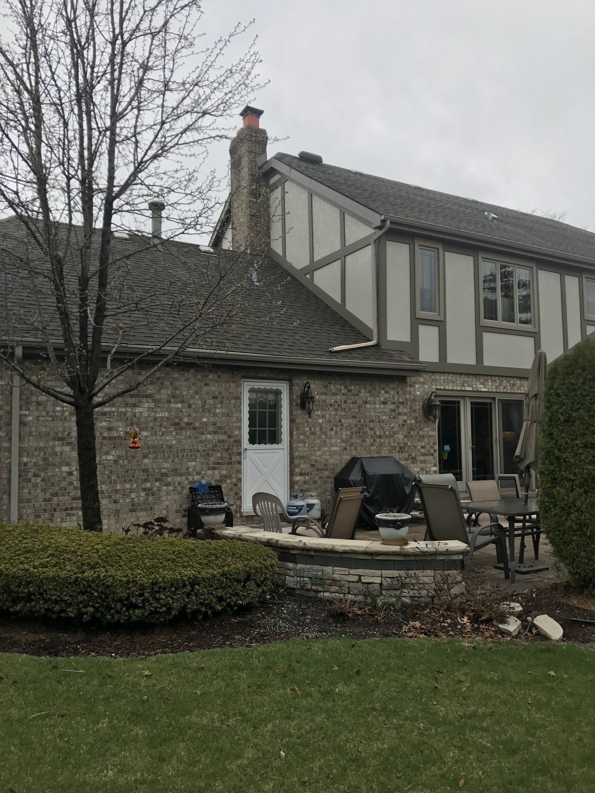 A large stone house with a patio area in front of it