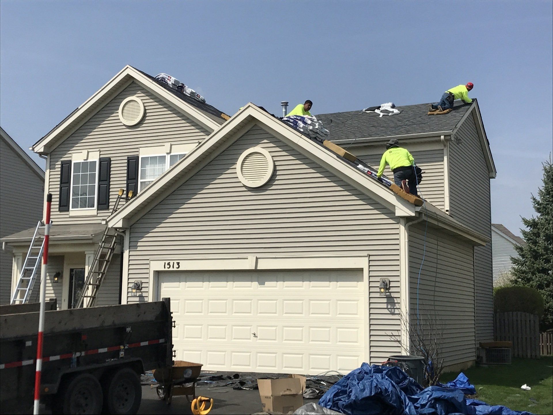 A group of men are working on the roof of a house.