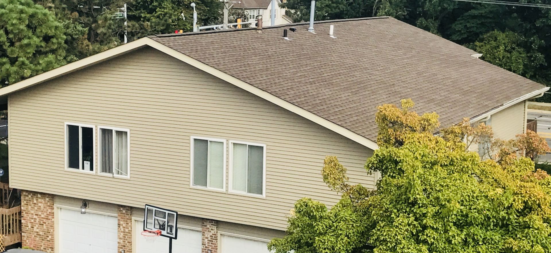 A large house with a basketball hoop in front of it.