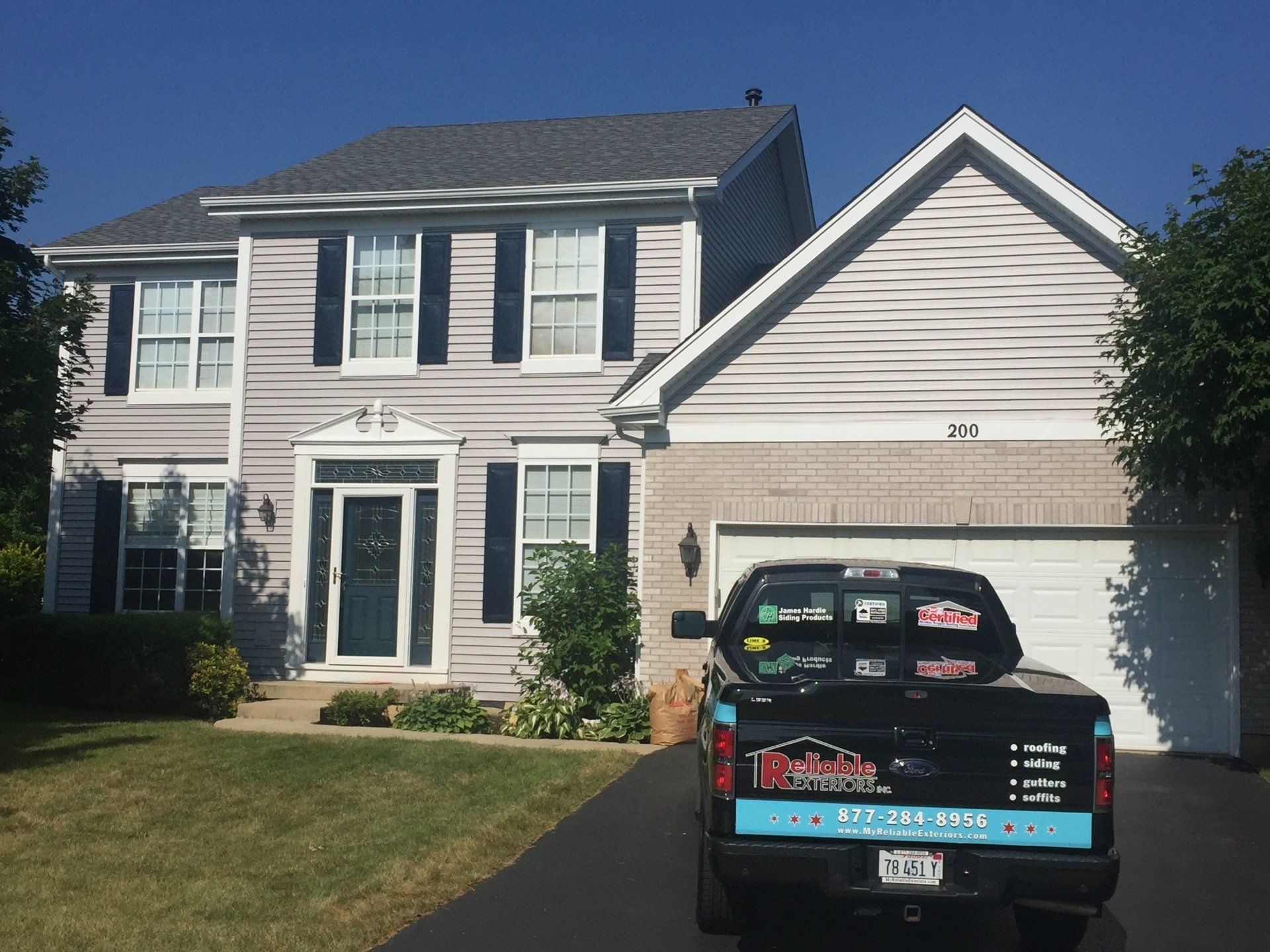 A truck is parked in front of a large house