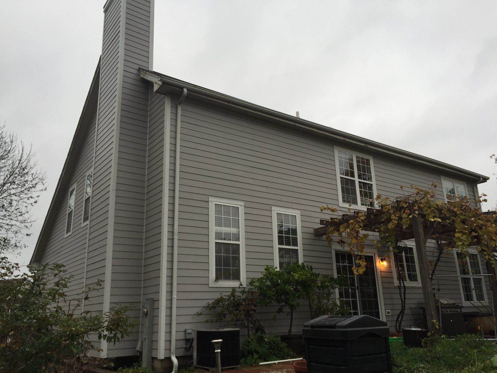 A large house with a chimney on the side of it.