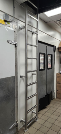 Une échelle en acier inoxydable est fixée à un mur dans une pièce.