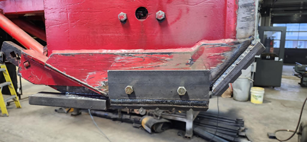 Une machine rouge et noire est assise dans un garage.