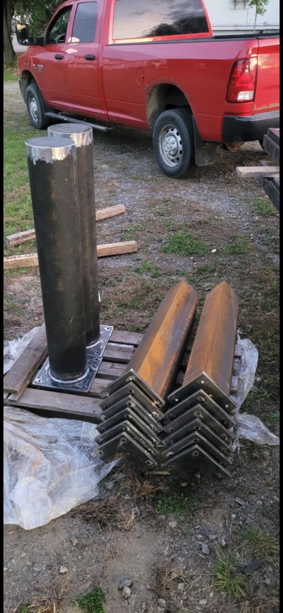 Un camion rouge est garé à côté d'un tas de métal.