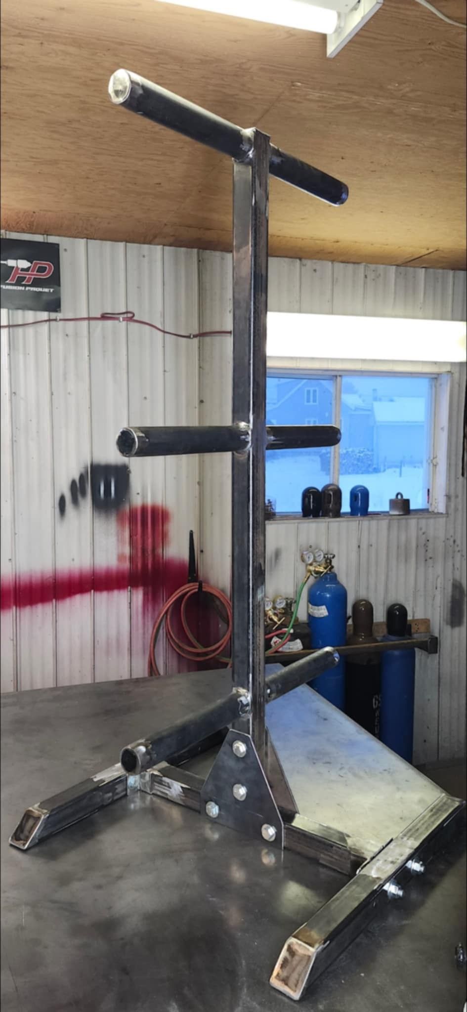 Un support d'haltères en métal est posé sur une table dans un garage.