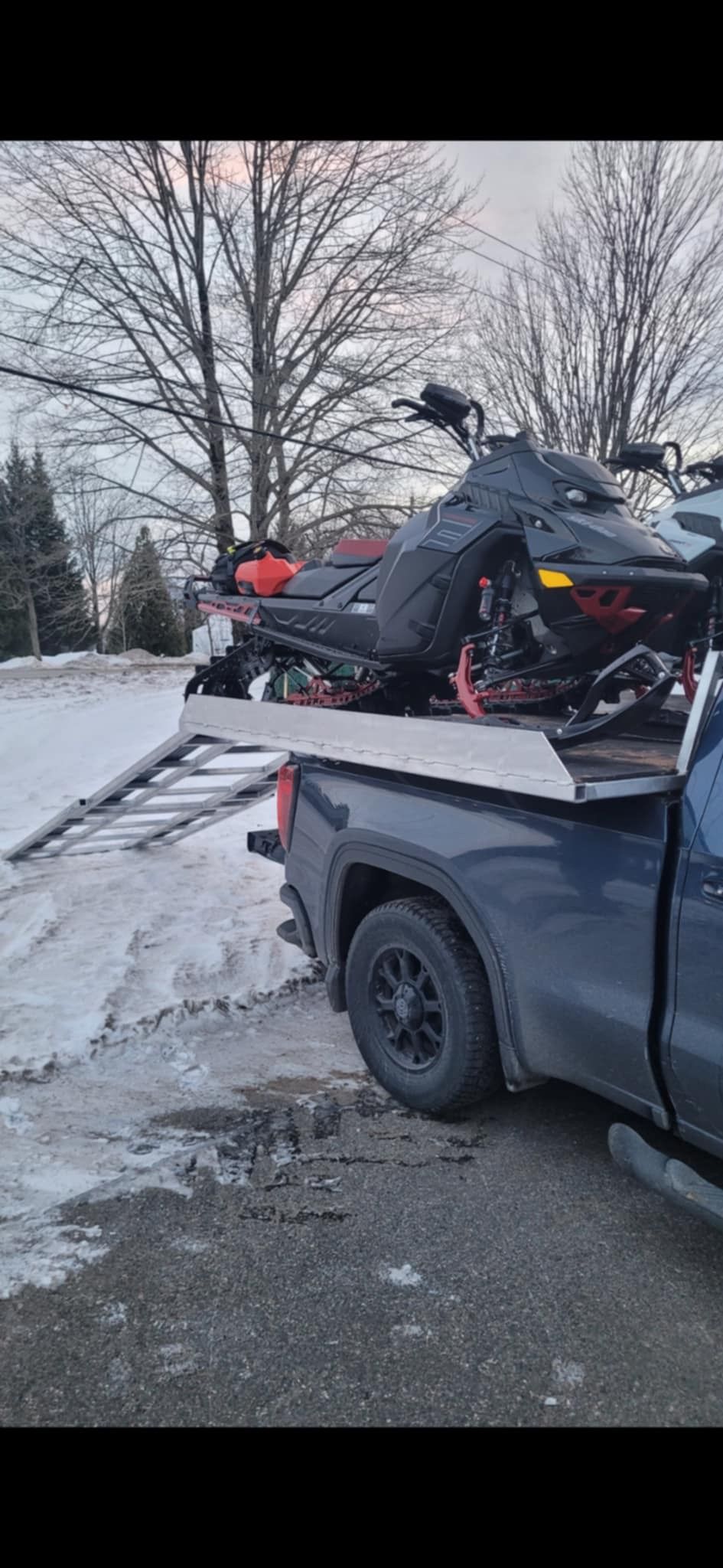 Une motoneige est remorquée à l'arrière d'un camion.