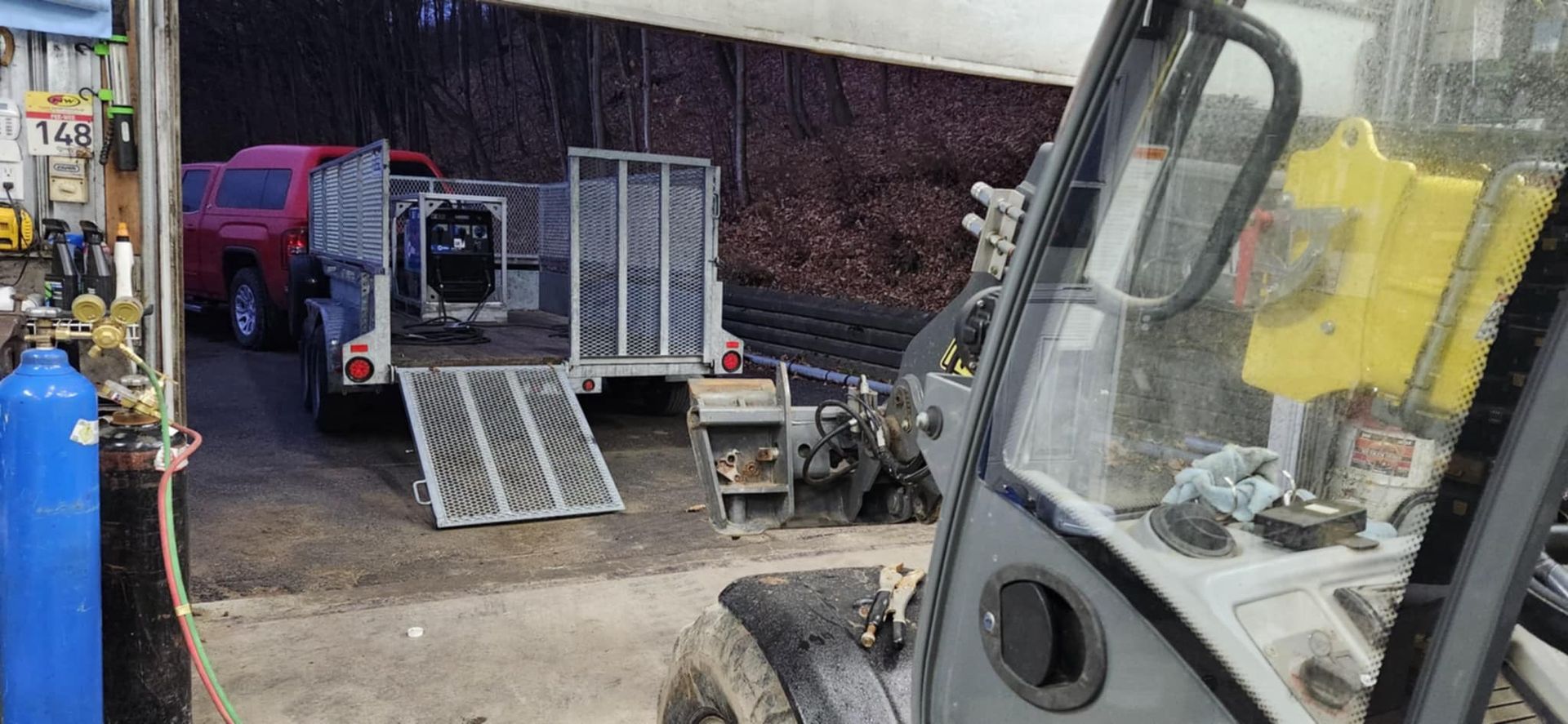 Un tracteur est garé dans un garage à côté d'une remorque.