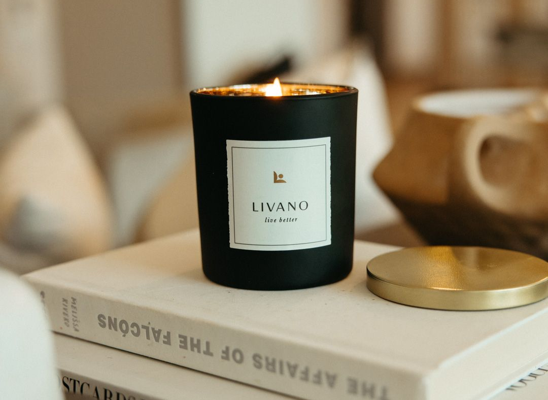 A lit black candle with a white label reading 