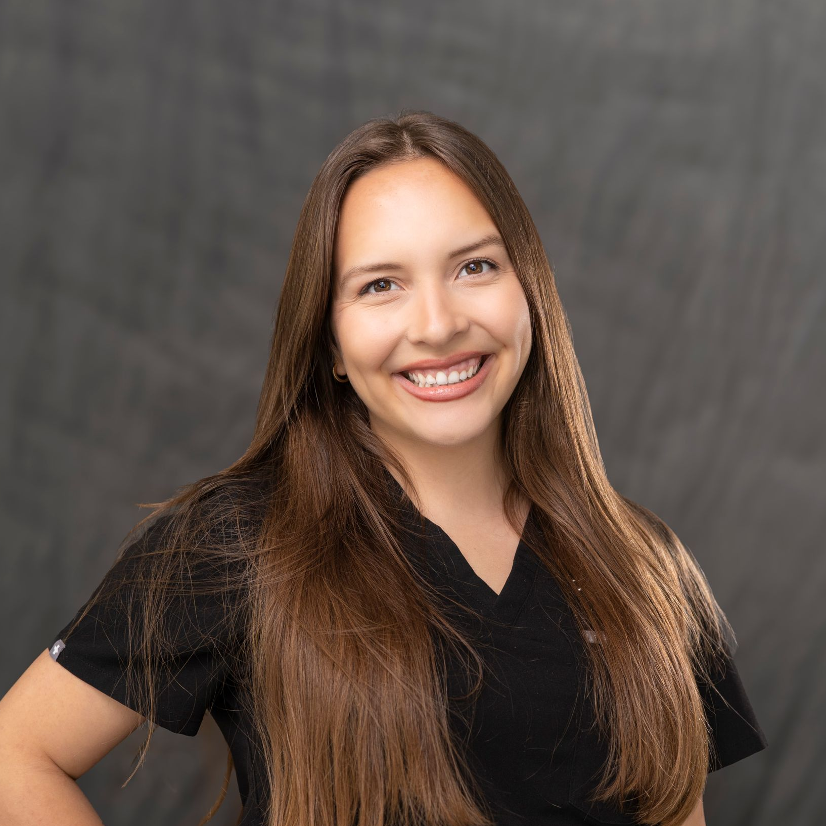 a woman wearing a black scrub top that says just spine