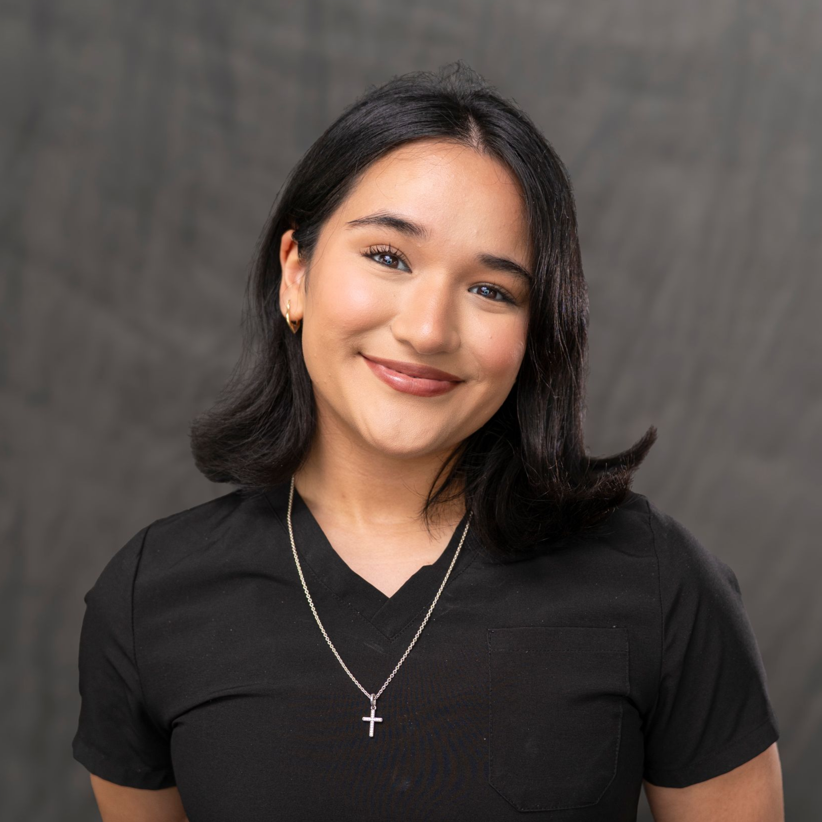 a woman wearing a black scrub top that says just spine
