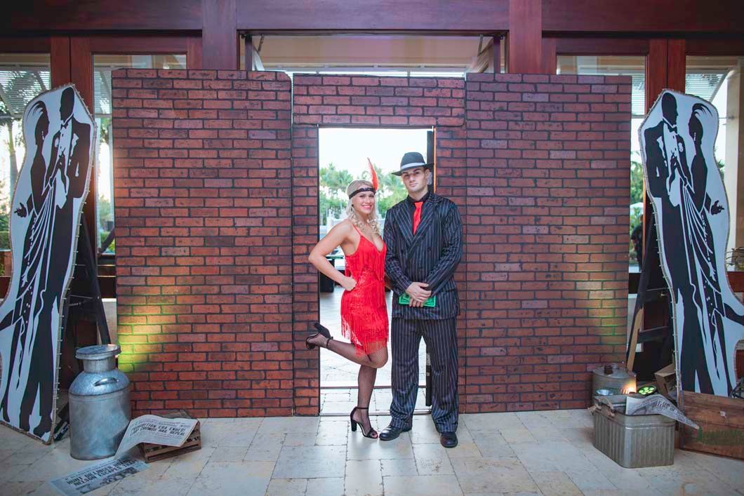 A man and a woman are standing in front of a brick wall.