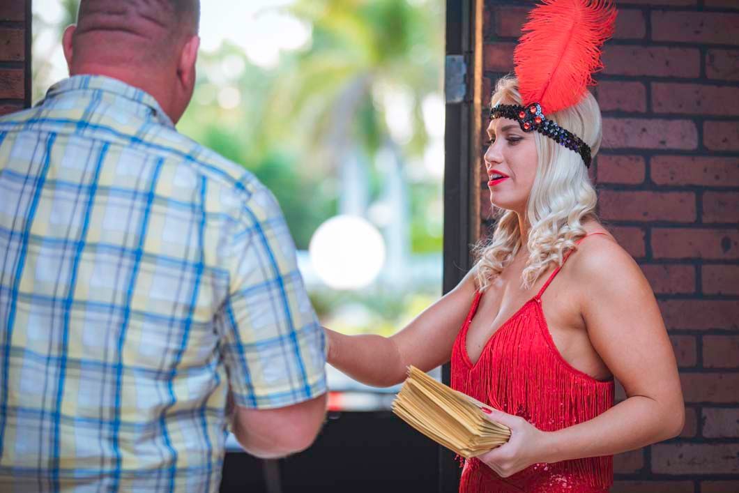 A woman in a red dress is talking to a man in a plaid shirt.