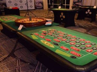 A roulette table with a roulette wheel on top of it.