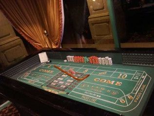 A green craps table with a lot of chips on it.
