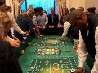 A group of people are playing roulette at a table in a casino.