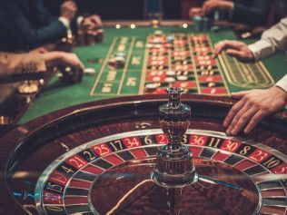 A group of people are playing roulette in a casino.