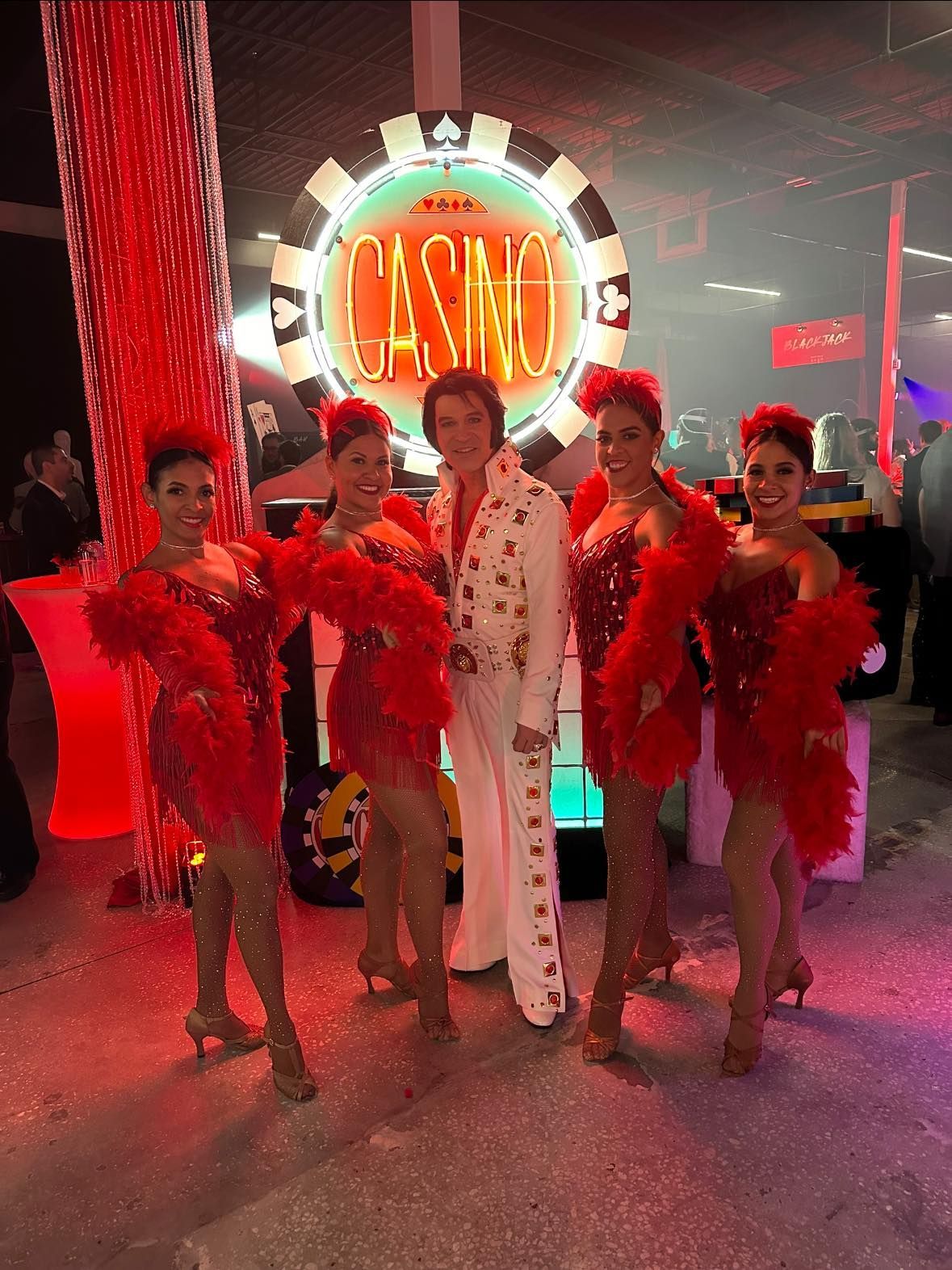 Two women wearing feathered hats and gloves pose for a picture