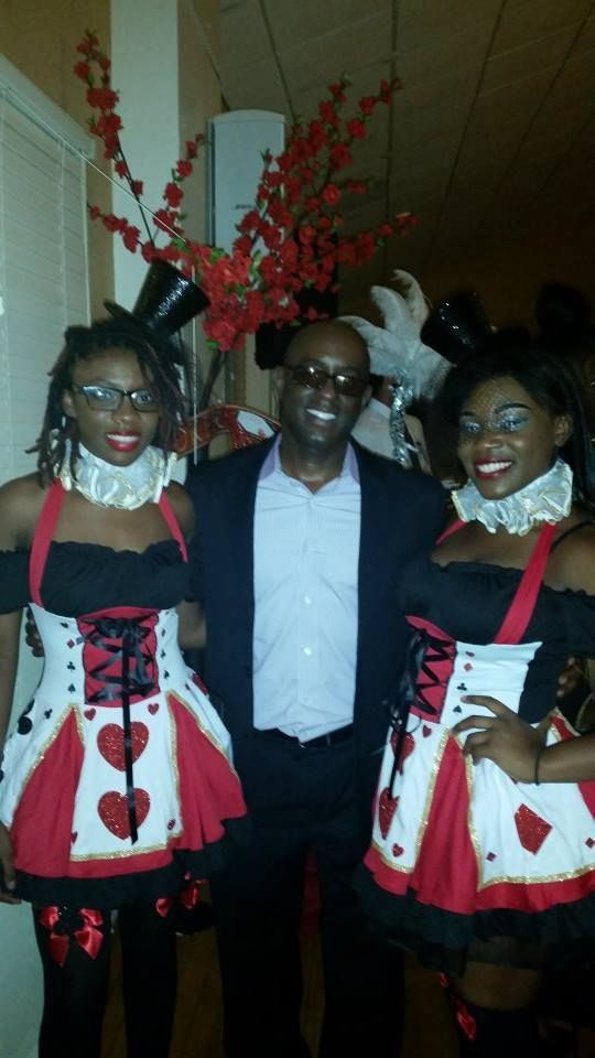 A man and two women dressed in queen of hearts costumes pose for a picture