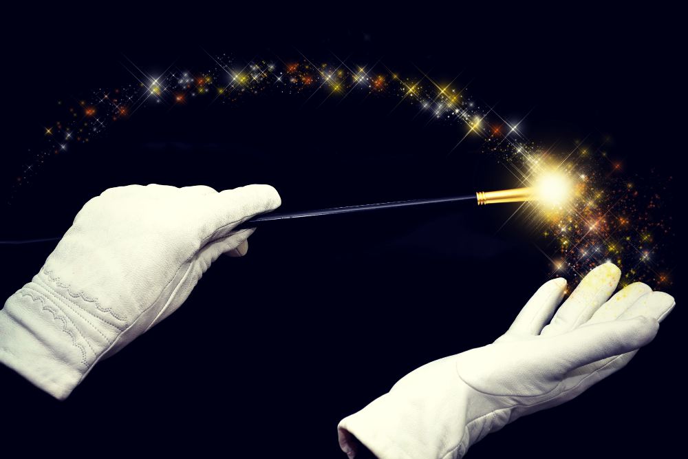 A person wearing white gloves is holding a magic wand.