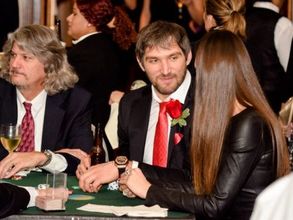 A group of people are sitting at a table playing poker