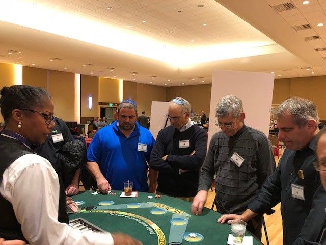 A group of people are playing a game of poker in a large room.