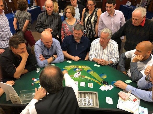 A group of people are playing a game of poker at a table.