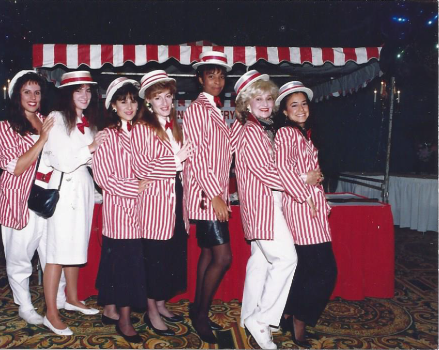 A group of women wearing red and white striped jackets and hats