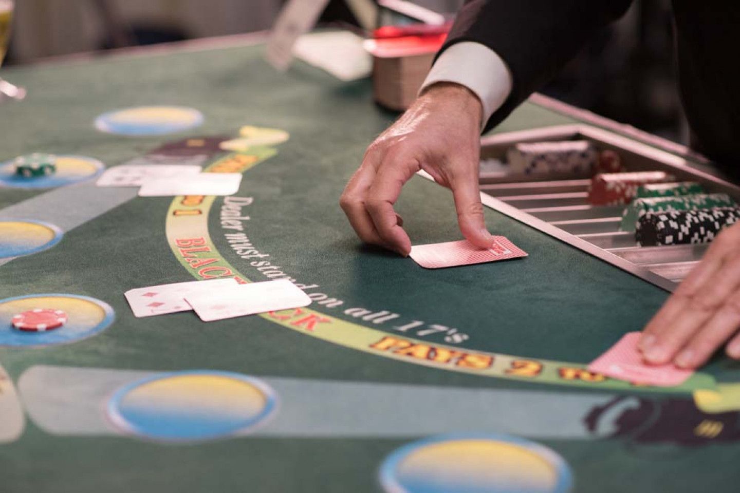 A person is playing a game of blackjack at a casino table.