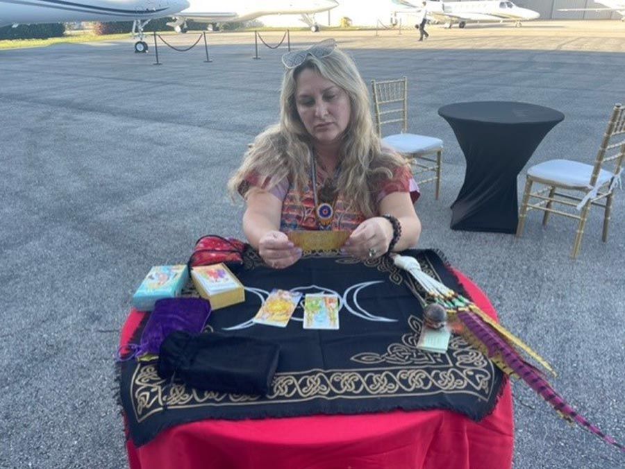 A woman is sitting at a table with tarot cards on it.