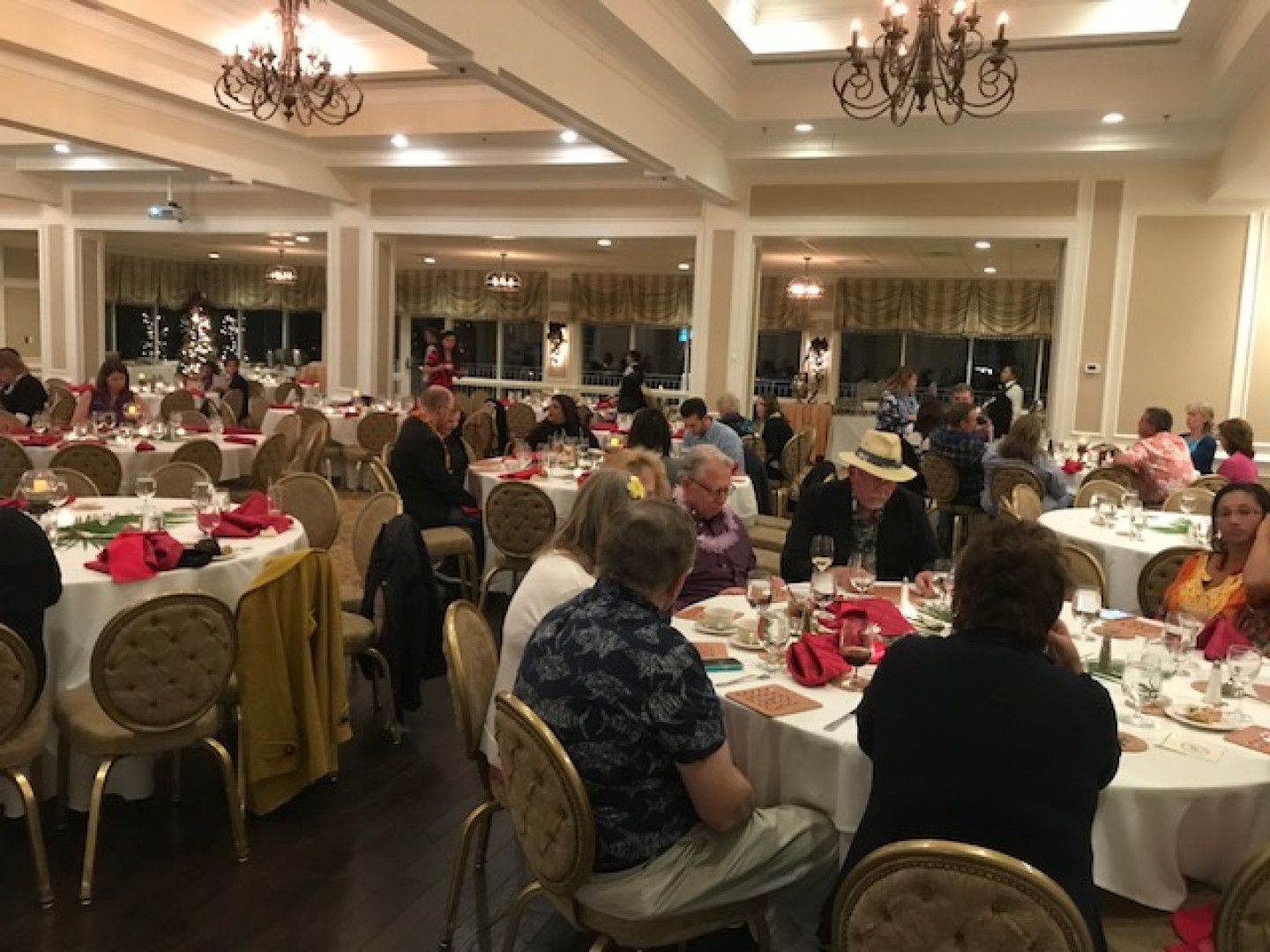 A group of people are sitting at tables in a large room.