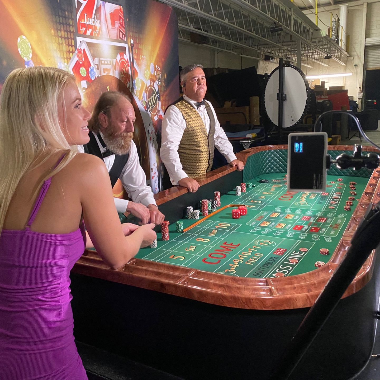 A woman in a purple dress is sitting at a roulette table