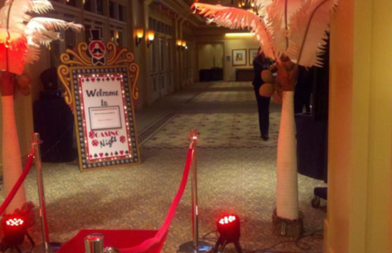 A hallway with a red carpet and a welcome sign