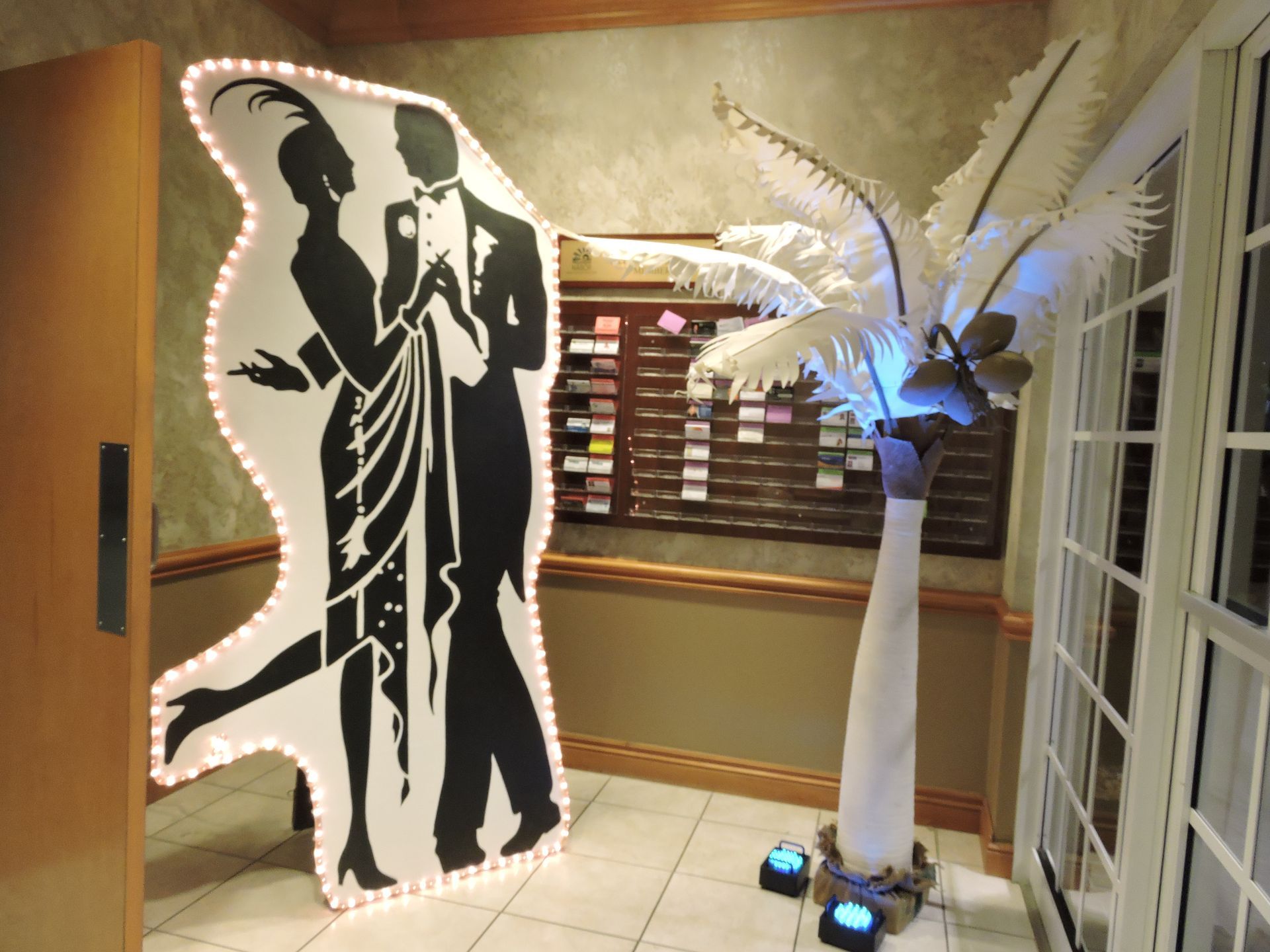 A cardboard cutout of a man and woman dancing next to a palm tree