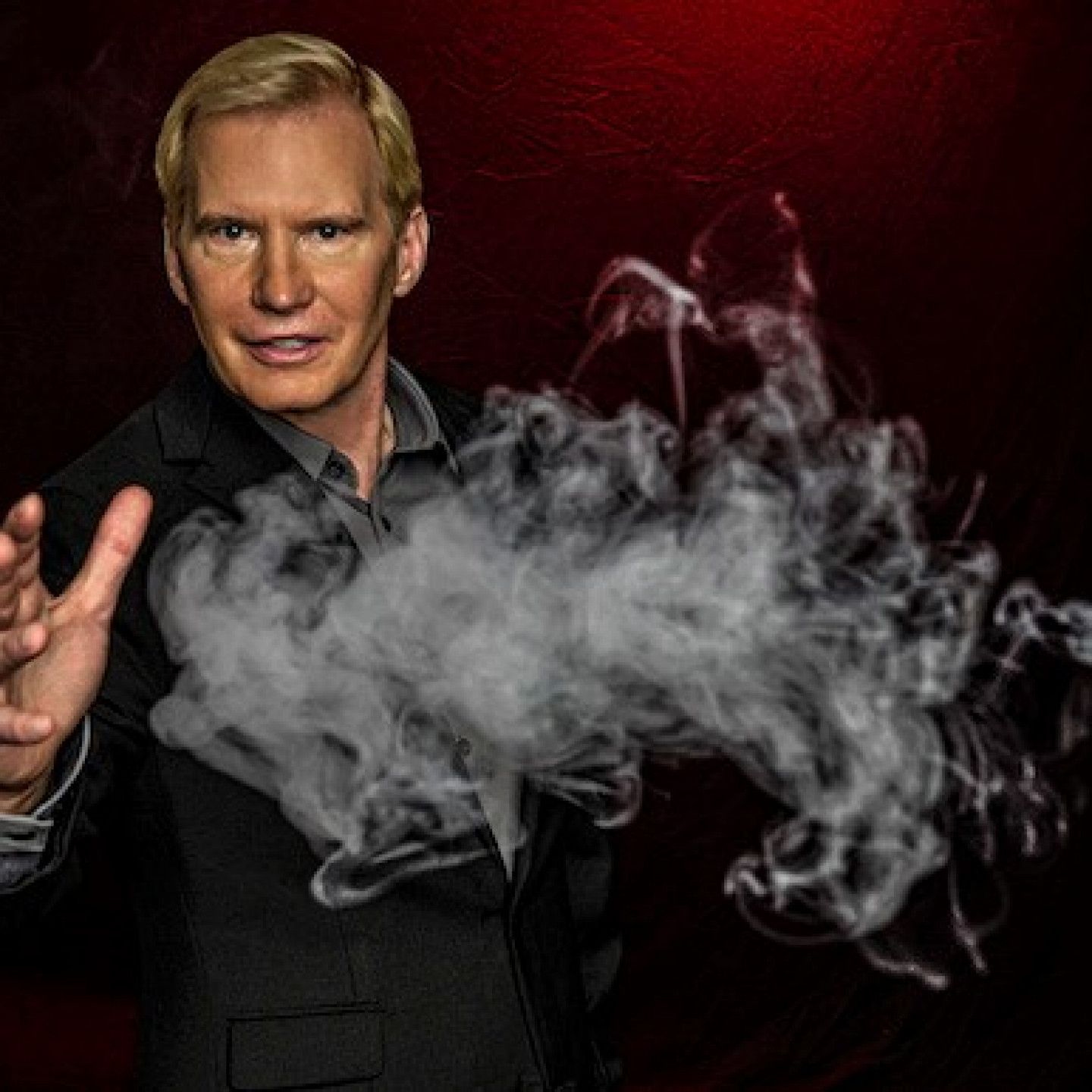 A man in a suit is surrounded by smoke coming out of his hand.